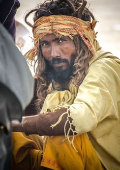 a man with long hair wearing a yellow outfit