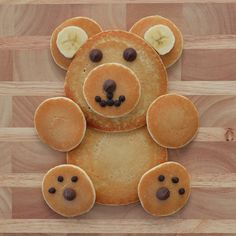 a teddy bear made out of pancakes on a wooden table