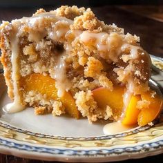 a close up of a piece of cake on a plate with icing and peaches