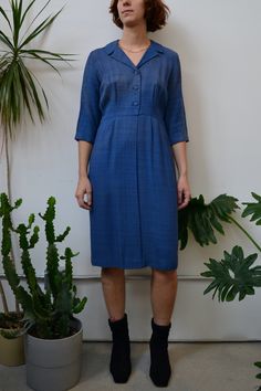 "Sixties Blue Woven Dress. Button Closure Up Bodice. Side Zipper Closure. Elbow Length Sleeves. Notched Collar. Unlined. No Content Label, Feels Like Rayon Good Vintage Condition - Sun Fading And Some Discolouration Throughout. Smells A Bit Musty. Fits Size Medium Chest - 38\" Waist - 30\" Hip - 38\" Shoulder to Shoulder - 15\" Shoulder to Hem - 42\" Sleeve Length - 16.5\" All Sales Are Final. We have taken the time to note all size measurements and the condition of each piece so please look ove Business V-neck Dresses With Button Closure, Casual Button-up Business Dress, Blue Knee-length Dress With Button Closure, Knee-length Business Dress With Buttons, Blue Mid-length Buttoned Dress, V-neck Business Dresses For Summer, Summer Business V-neck Dresses, Business V-neck Dresses For Summer, Business V-neck Summer Dresses