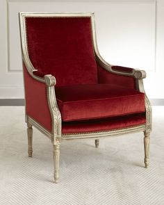 a red velvet chair with gold trimming