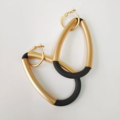 "A beautiful black and gold statement earrings. Elegant and sophisticated earrings that will upgrade any elegant outfit! Share with the world your exquisite taste! Available in silver plating as well. Lightweight earrings. * * * * * * * * * * * Materials: 24k gold plated brass - matte finish Silver plated brass - matte finish 0.20\"/5m\"m thick black silicon cord Measurements: Total length: 2.95\"/7.5 c\"m Width: 1.57\"/4 c\"m Hoop diameter: 0.79\"/2 c\"m Thickness: 0.24\"/6 m\"m * * * * * * * * Elegant Matte Gold Earrings For Party, Elegant Matte Gold Party Earrings, Bold Black Drop Earrings, Modern Black Hoop Earrings For Party, Chic Black Hoop Earrings For Party, Chic Black Hoop Earrings, Chic Black Evening Earrings, Chic Black Metal Earrings, Silver Statement Necklace