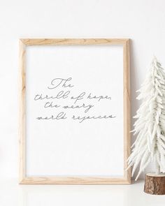 a white christmas tree next to a wooden frame with the words, the little things are very wonderful