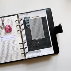 an open book on top of a table next to a pair of scissors and a pen