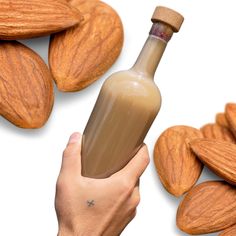 a hand holding a bottle filled with almonds