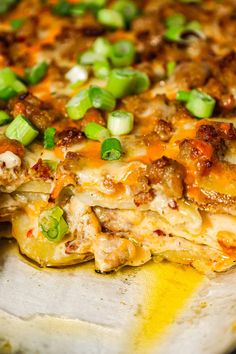 a close up of a pizza with cheese and green onions