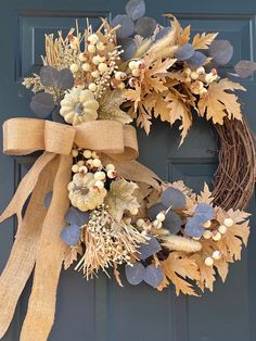 a wreath on the front door with leaves and berries hanging from it's side