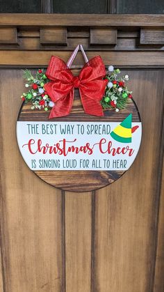 a wooden door with a sign that says the best way to spread christmas cheer is singing loud for all to hear