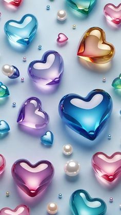 many different colored hearts and pearls on a white surface with water droplets in the middle