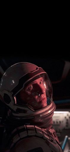 a man in a space suit and helmet looking into the distance with his eyes closed