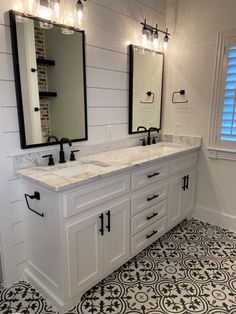 a bathroom with two sinks, mirrors and tile flooring in the middle of it