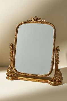 a mirror sitting on top of a table next to a white wall in the background