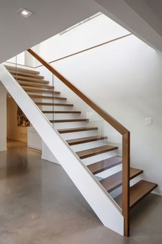 a wooden and glass stair case in an empty room