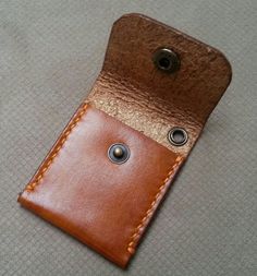 a brown leather case with two buttons on it