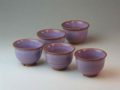 five purple cups sitting next to each other on a table