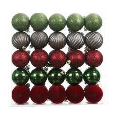 christmas ornaments are arranged in a clear box on a white background, including green and red balls