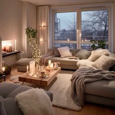 a living room filled with lots of furniture next to a large window covered in candles