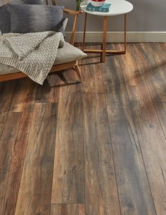 a living room with wood flooring and a white table in front of the couch