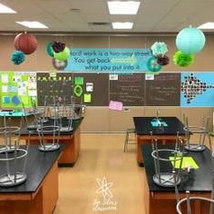 an empty classroom with desks, chairs and decorations on the back wall in front of a bulletin board