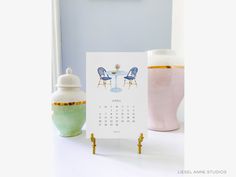 a calendar sitting on top of a table next to a vase