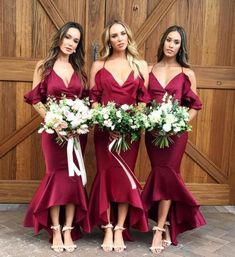 three women in red dresses standing next to each other with bouquets on their laps