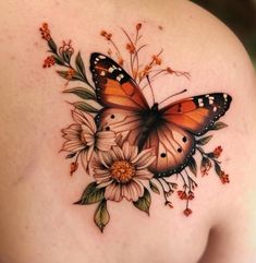 a woman's back with a butterfly and flowers on it