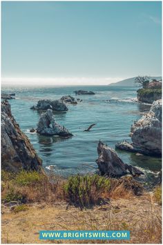 an ocean view with rocks in the water