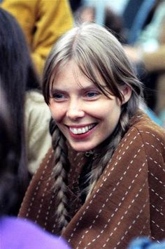 a woman with braids smiling at the camera