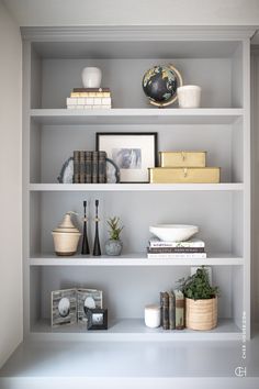 the shelves are filled with books, vases and other decorative items in white paint