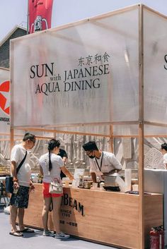 some people are standing at a food stand