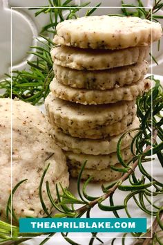 a stack of crackers sitting on top of a white plate next to green leaves