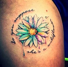 the back of a woman's shoulder with a flower on it and words written in cursive writing