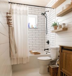 a bathroom with a toilet, sink and bathtub next to a wooden cabinet in the corner