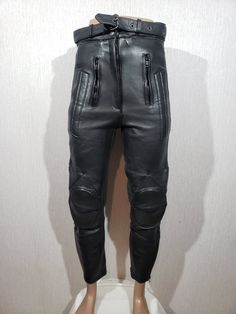 Gorgeous black leather biker pants for women. Black leather pants with light protection. The wonderful pants are made of durable, dense, soft black genuine leather. The pants are easily fastened with a plastic zipper, metal snaps and a belt with a metal buckle. The pants have two front pockets with a zipper. A notable detail of these pants is the inserts on the knees and the perforated leather on the sides. The pants have plastic zippers at the bottom. The pants have a wide waistband and a half-zip for fastening the jacket. The pants have a nice polyester lining. The pants are comfortable, pleasant and reliable for riding a motorcycle and will definitely make you stand out from the crowd and draw attention to you. MEASUREMENTS Pants length                                     95 cm  |  37.5 Fitted Leather Bottoms For Biker Events, Fitted Biker Leather Pants, Fitted Leather Moto Bottoms, Fitted Full Length Biker Leather Pants, Leather Full Length Pants For Biker Events, Full Length Leather Pants For Biker Events, Fitted Leather Motorcycle Bottoms, Fitted Biker Leather Pants With Belt Loops, Black Biker Pants With Zip Fly