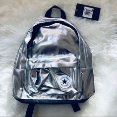 Converse Silver Metallic Mini Backpack New A Shiny Metallic Surface Styles A School-Gear Essential Backpack Built In A Classic Two-Compartment Design. Two-Way Zip Closure Top Carry Handle; Adjustable Shoulder Straps Exterior Zip Pocket Height 17 1/2” Width 11 1/2” Depth 5” Happy Poshing Silver School Bag With Zipper Closure, Casual Silver Backpack For School, Trendy Silver Backpack For School, Silver Backpack For Back To School, Trendy Silver Backpack, Silver School Backpack, Silver Standard School Backpack, Silver Standard Backpack For Everyday Use, Silver Standard Backpack For Daily Use