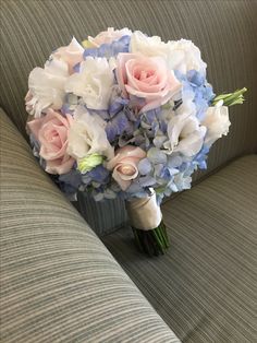 a bouquet of flowers sitting on top of a couch next to a gray sofa cushion