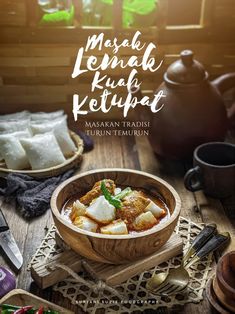 a bowl filled with food sitting on top of a wooden table next to other dishes