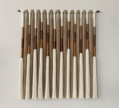 a group of brushes sitting on top of a white table next to some brown and white sticks