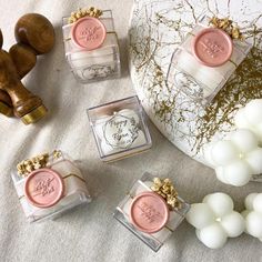 four small square soaps sitting next to each other on a white table with gold accents