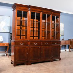 a large wooden bookcase sitting on top of a hard wood floor next to a desk