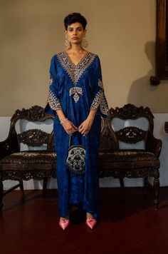 Editor's Note Featuring a deep blue self-woven kaftan with hand embroidery on yoke and cuffs. This elegant piece comes embellished with careful antique embroidery detailing. Color: Blue Fabric: Russian jacquard Component: Kaftan Fit: Relaxed Occasion: Resort and evening wear Care: Dry Clean Only About the Designer Paulmi & Harsh is a luxury prêt label inspired by beautiful botanicals. Paulmi & Harsh design strong, feminine silhouettes with prints and delicate detailing, fusing 1950’s fashion wit Luxury Royal Blue Kurta For Festive Occasions, Luxury Traditional Royal Blue Kurta, Luxury Semi-stitched Festive Kaftan, Luxury Royal Blue Festive Kurta, Luxury Blue Bollywood Kaftan, Luxury Blue Traditional Wear For Ceremonial Occasion, Luxury Blue Ceremonial Kaftan, Luxury Blue Embellished Kaftan, Elegant Luxury Blue Traditional Wear