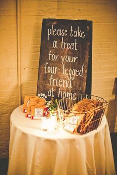 a table with a sign that says please take a treat for your four legged friend at dinner