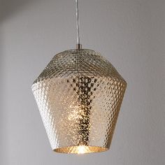 a close up of a light fixture hanging from a ceiling with white walls in the background