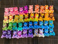 there are many different colored teddy bears on the bed with each one's own