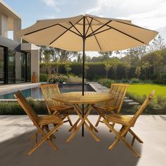 a table and chairs with an umbrella in front of a swimming pool on a sunny day