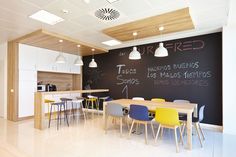 a chalkboard wall in the middle of a room with chairs and tables around it