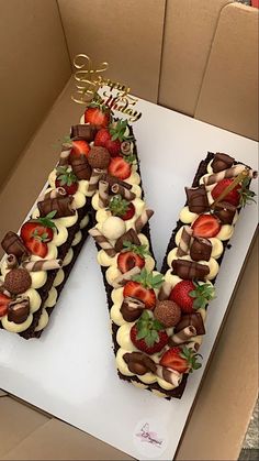 there is a letter made out of chocolate and strawberries on the top of it