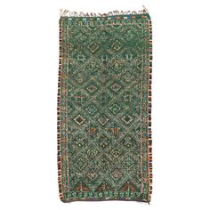 a green rug with fringes on the bottom and an intricate design in the middle