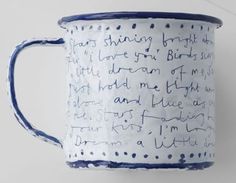 a blue and white mug with writing on it