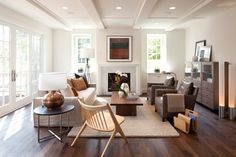 a living room filled with furniture and a fire place in the middle of a room